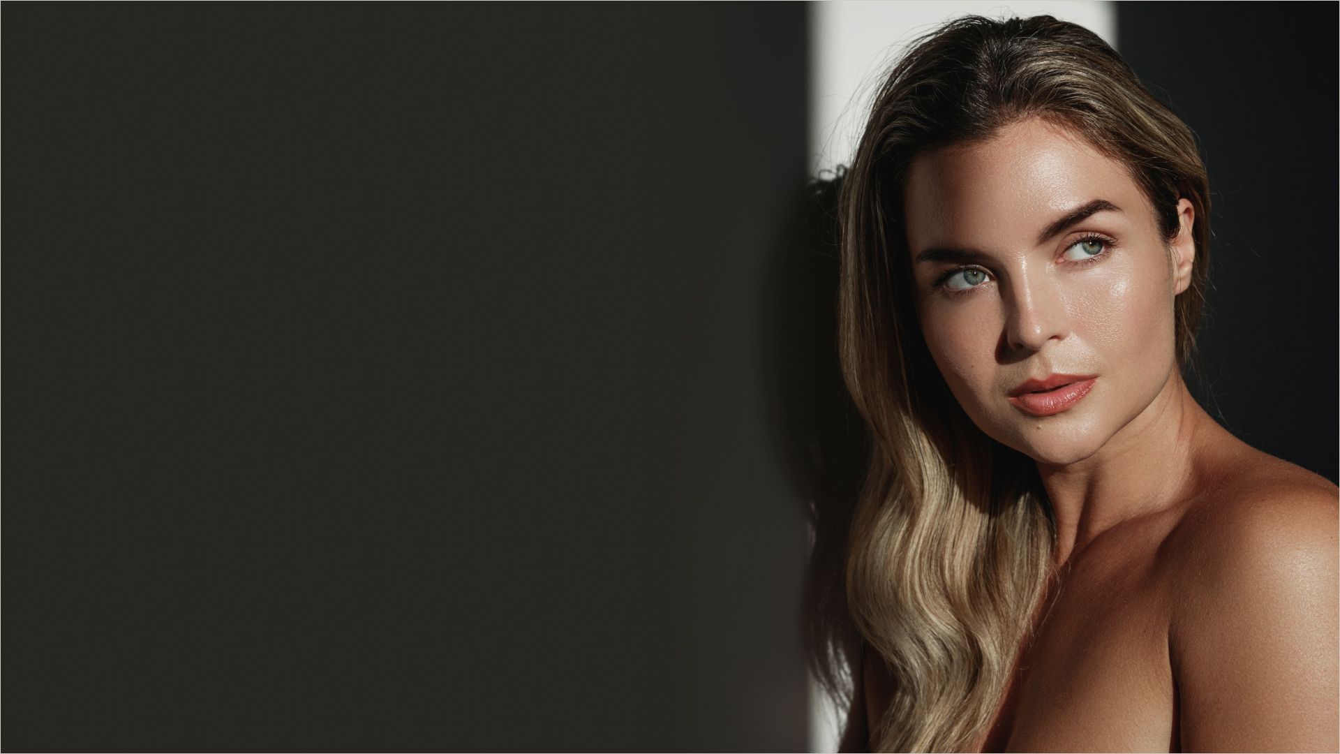Model with long hair in dramatic lighting.