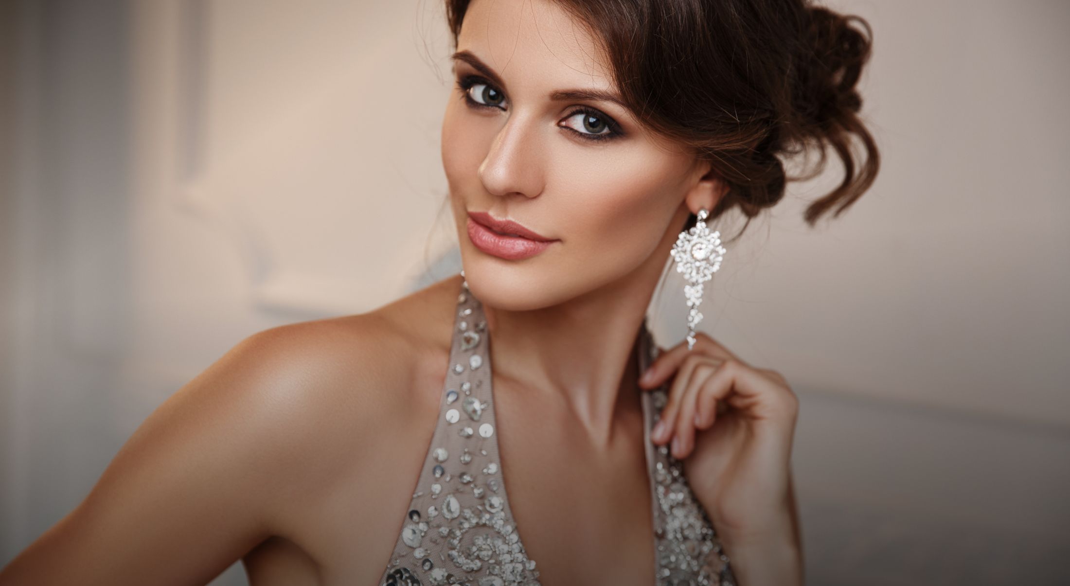 elegant woman wearing a silver dress and earrings